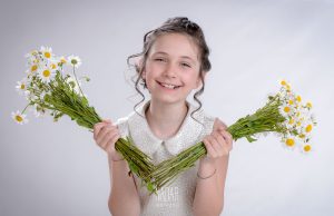 Bambina con fiori durante servizio fotografico prima comunione