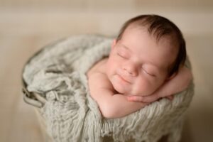 neonata che dorme dentro un secchio durante servizio fotografico