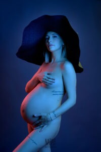 Donna in gravidanza fotografata in studio con luci colorate